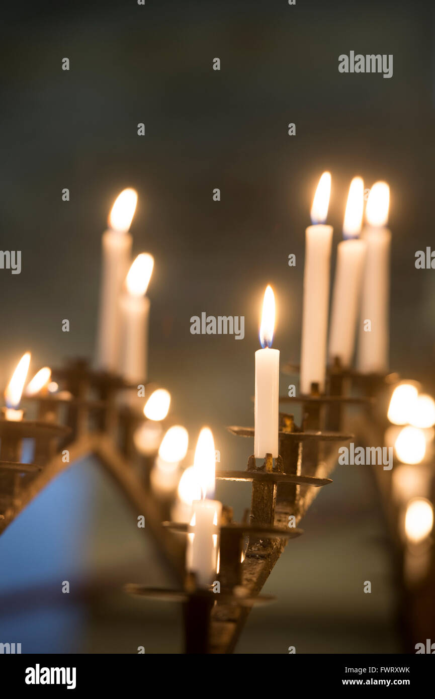 Illuminato nella preghiera candele in Tewkesbury Abbey, Gloucestershire, Inghilterra Foto Stock