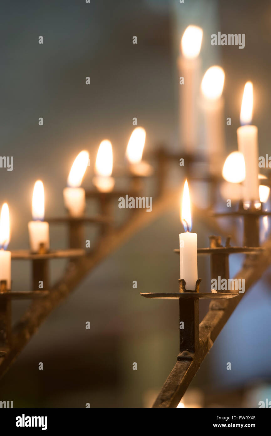 Illuminato nella preghiera candele in Tewkesbury Abbey, Gloucestershire, Inghilterra Foto Stock