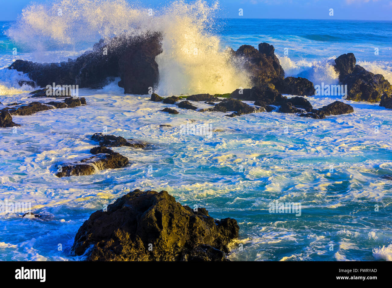 Sunrise enorme di onde che si infrangono sulla lava formazioni rocciose Ho'okipa Beach, Maui Foto Stock