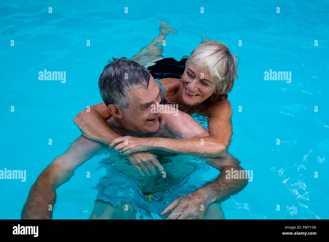 Felice coppia senior in piscina Foto Stock