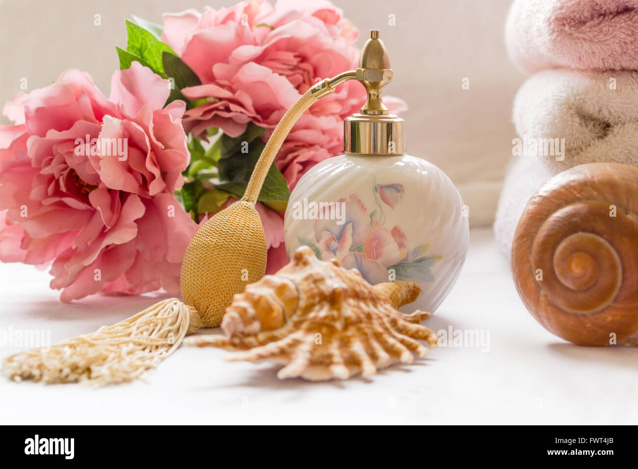 La disposizione del bagno con bottiglia di profumo e graziosi fiori Foto Stock