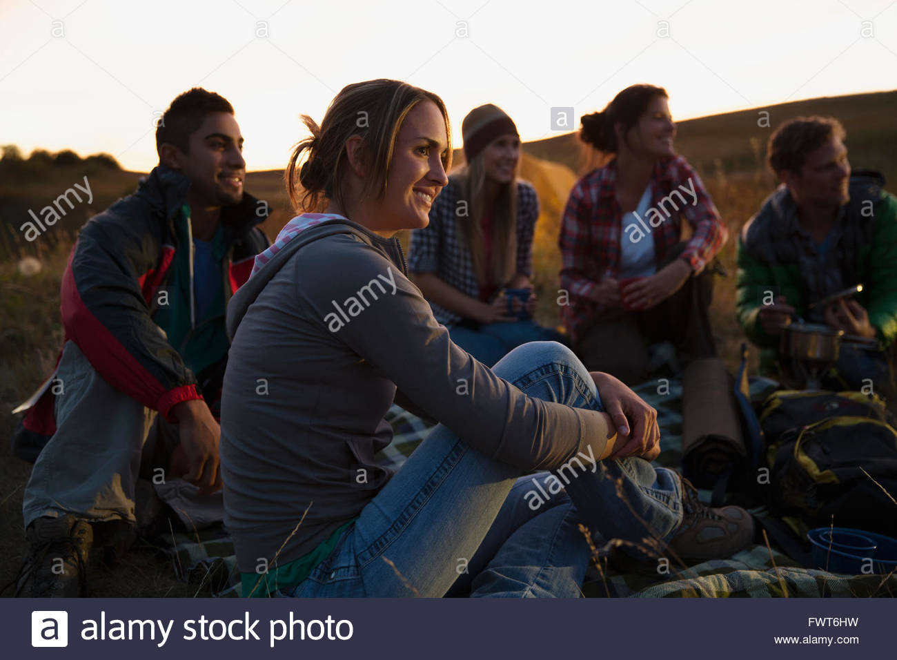Amici seduti all'aperto al tramonto. Foto Stock