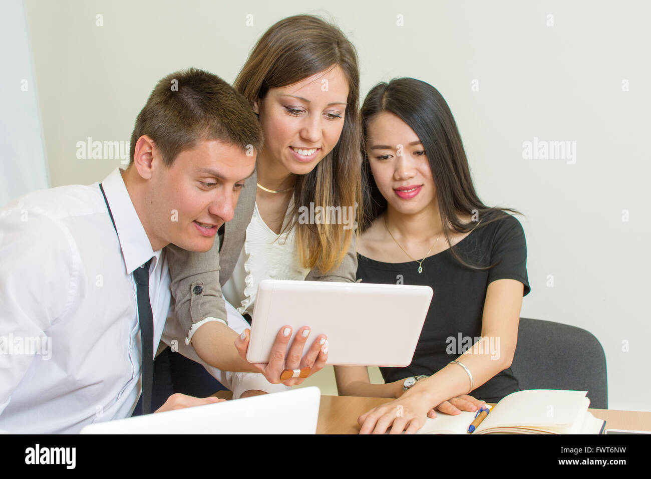 Team Multiculturale guardando un tablet in ufficio Foto Stock