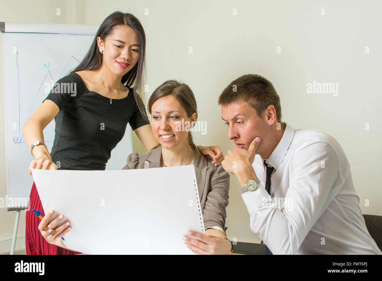 Team Multiculturale di progettisti guardando un progetto sul lavoro Foto Stock