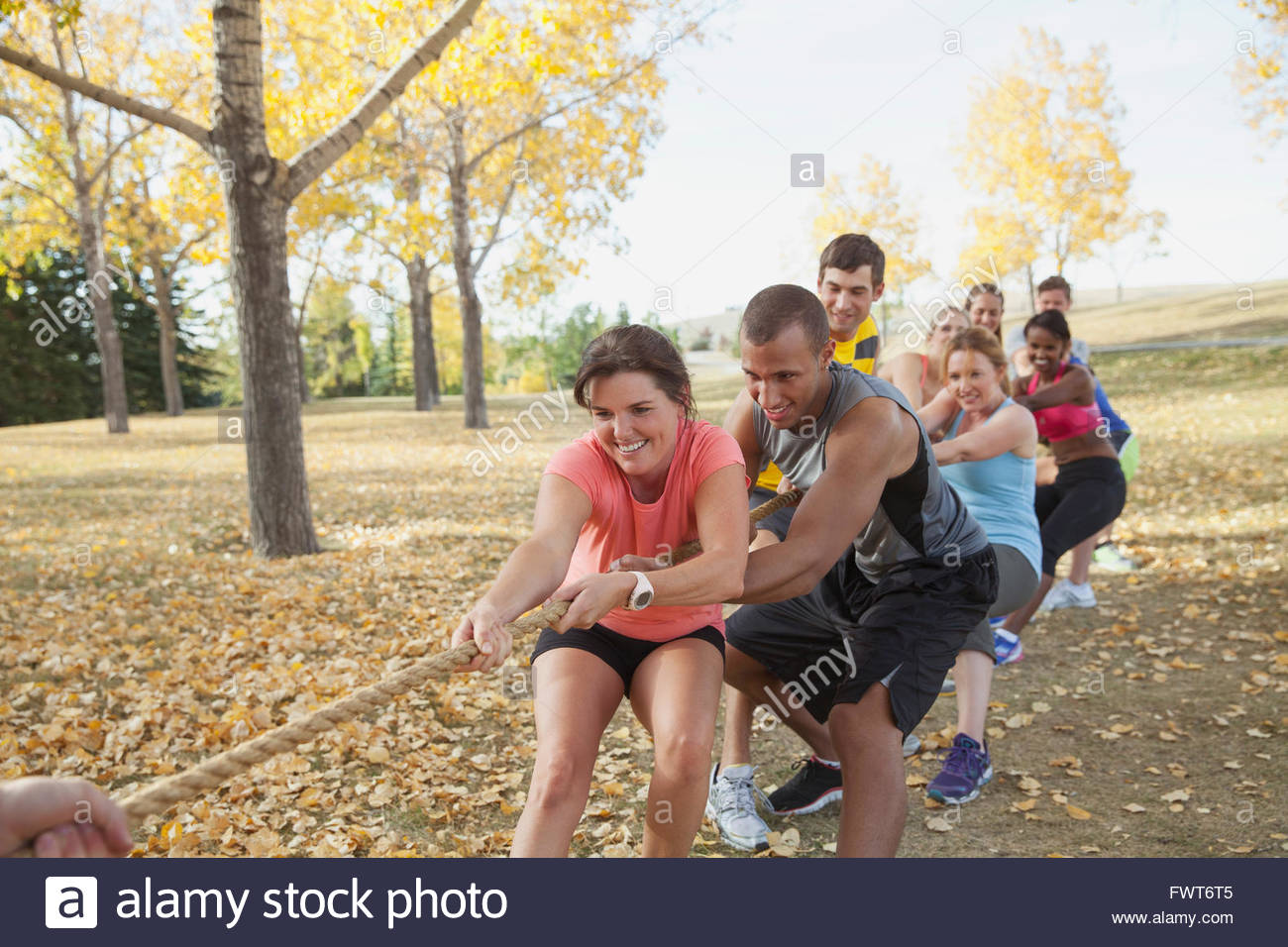 Lezione di fitness facendo rimorchiatore di guerra all'esterno. Foto Stock