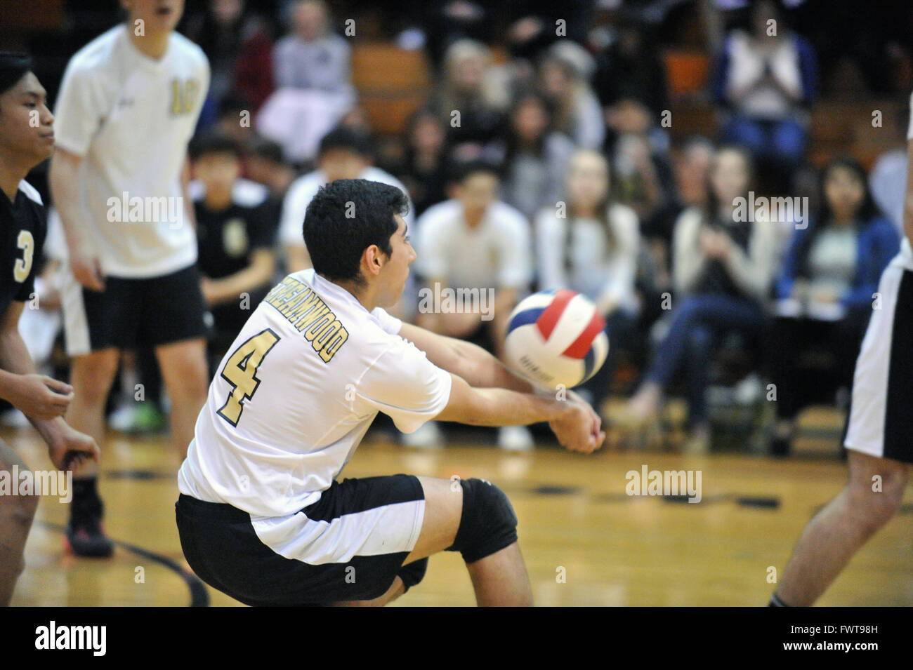 Player andando basso per tornare a servire e iniziare una raffica durante una scuola di pallavolo match. Stati Uniti d'America. Foto Stock