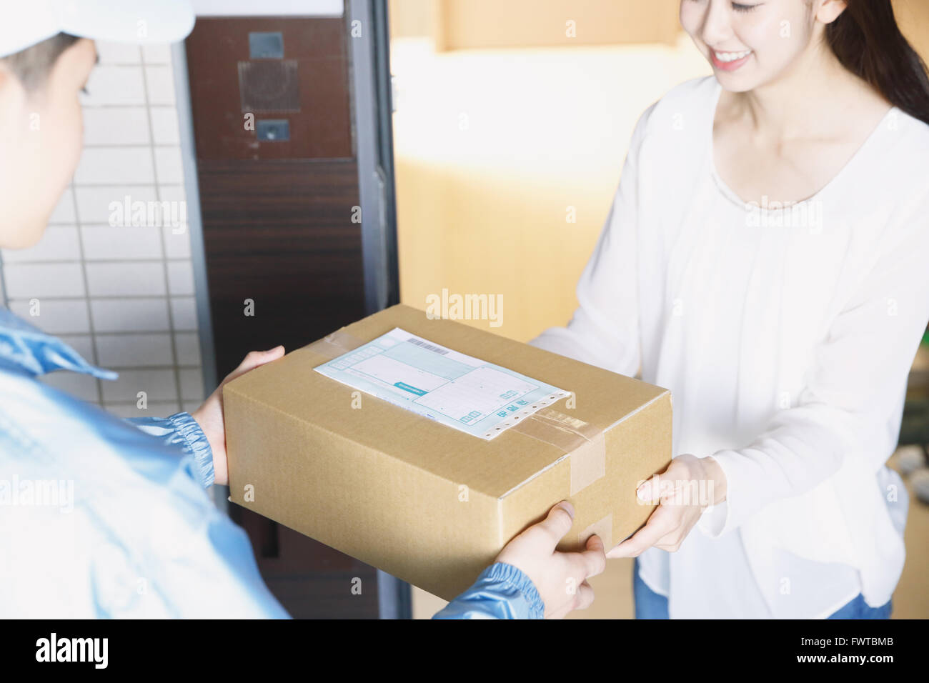 Giovane donna giapponese come ottenere il pacchetto da uomo di consegna Foto Stock