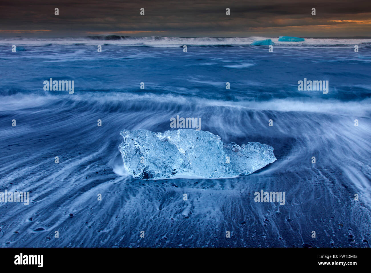 Blocco di fusione del ghiaccio lavato sulla spiaggia lungo l'Oceano Atlantico costa al Breidamerkursandur sabbie nere in inverno, Islanda Foto Stock