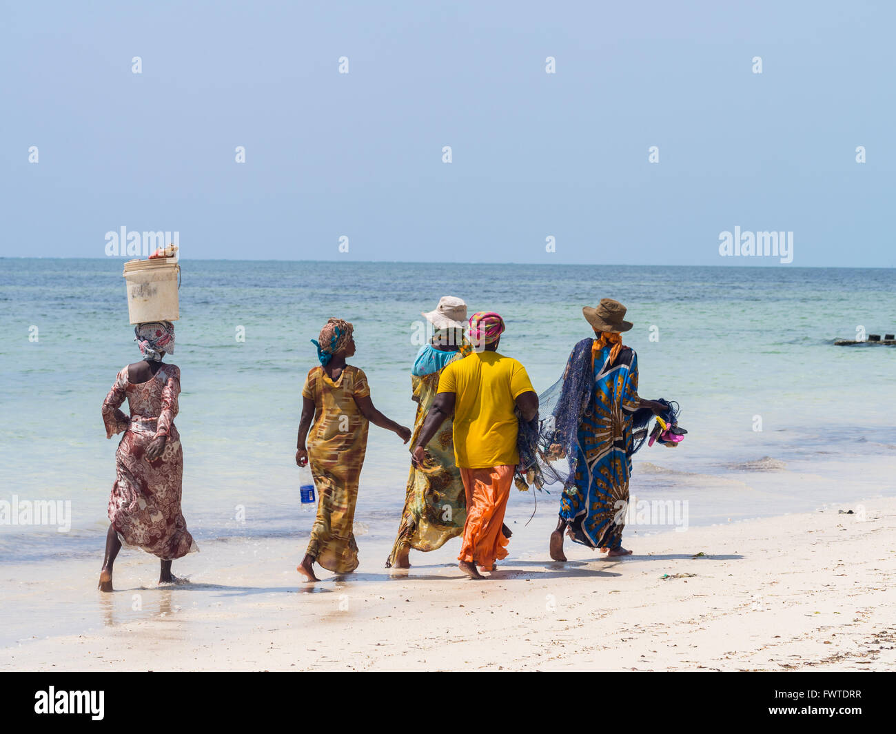 Donne locali andare a pesca su una spiaggia a Zanzibar, Tanzania. Foto Stock