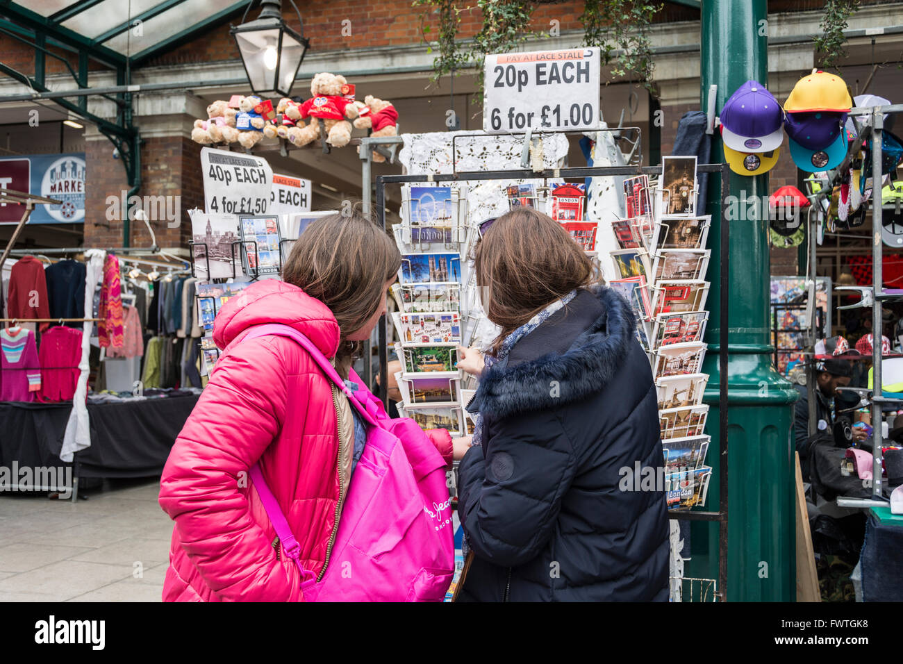 Due donne scegliere cartoline a Londra il mercato di Covent Garden Foto Stock