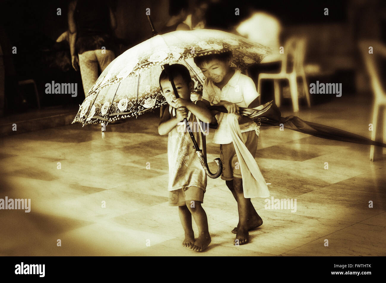 I bambini stanno giocando con un ombrello sul cimitero Cinese, dove persone senza dimora vivono. Cebu City, Filippine. Foto Stock