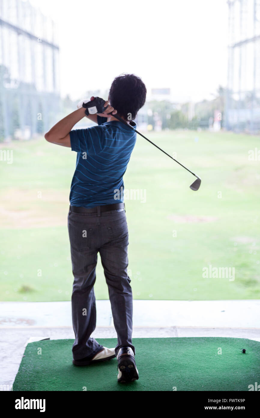 Giovane maschio golfista praticando il suo drive Foto Stock