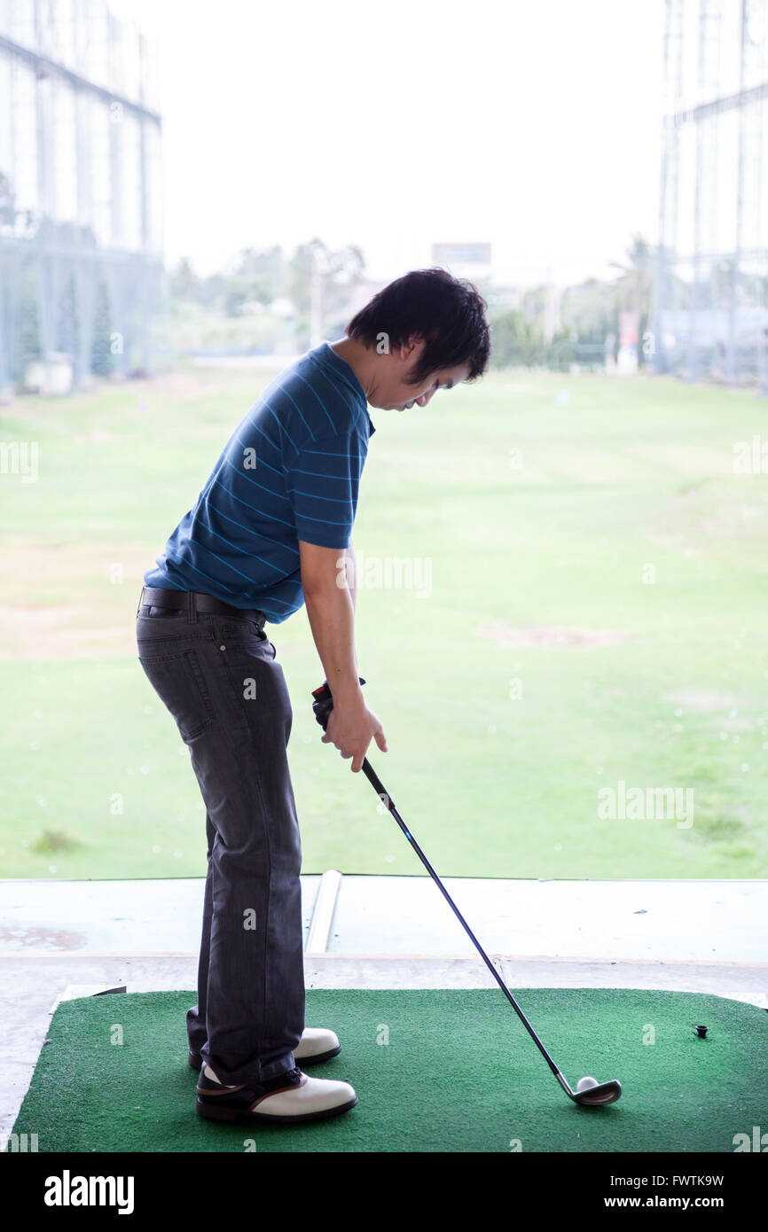 Giovane maschio golfista praticando il suo drive Foto Stock