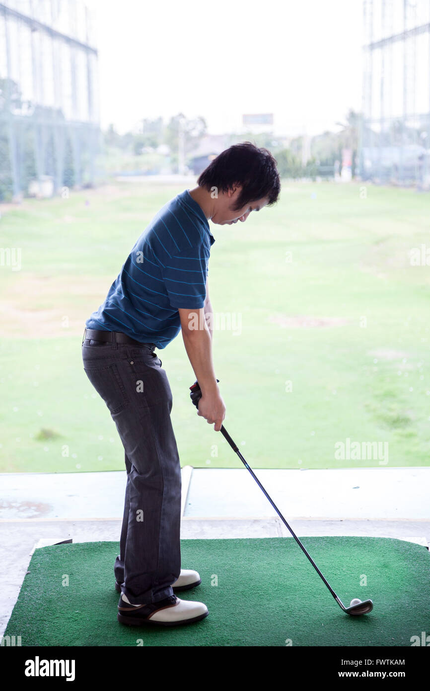 Giovane maschio golfista praticando il suo drive Foto Stock