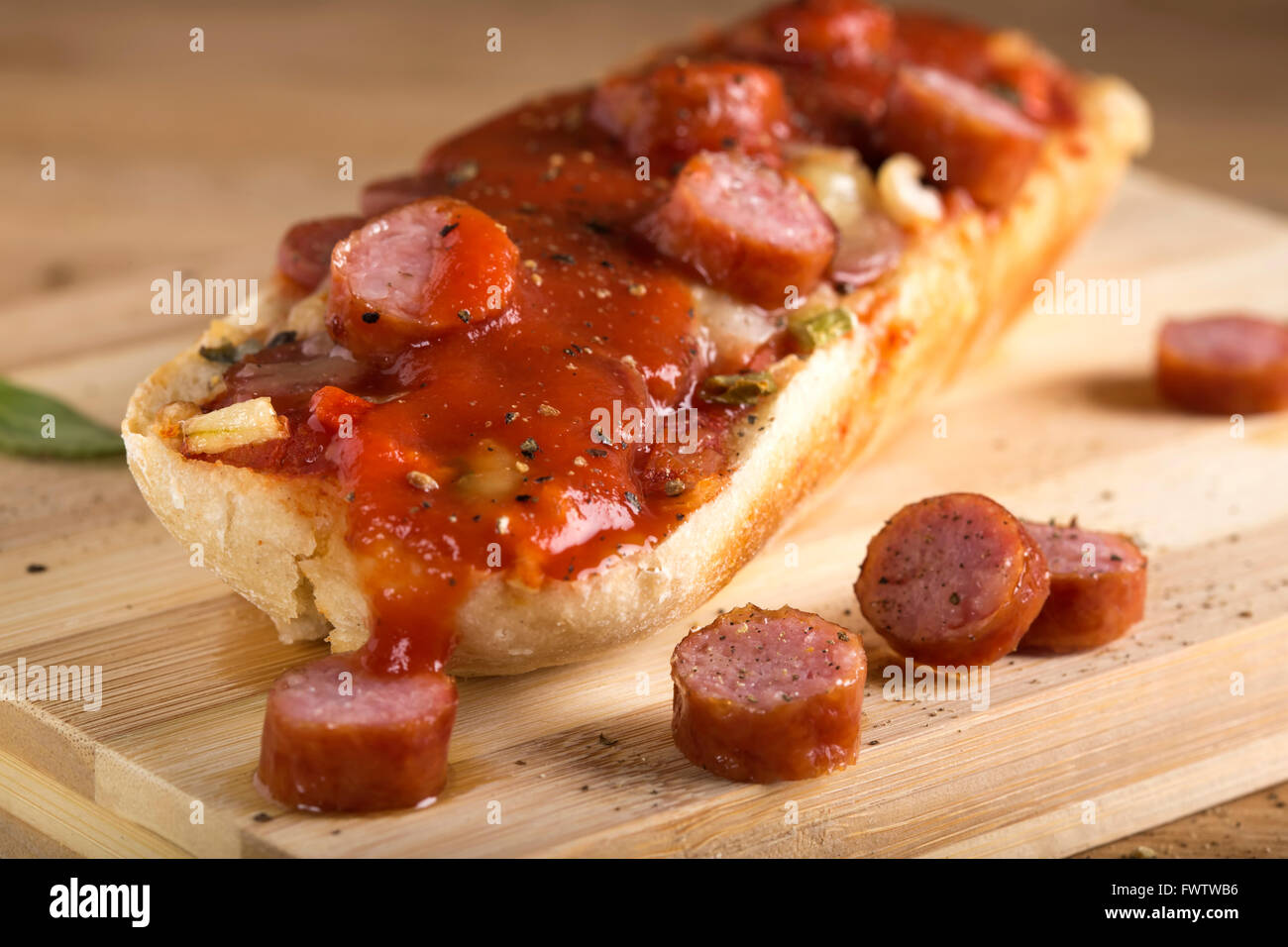 Pizza baguette con salsa di pomodoro sul tagliere di legno Foto Stock