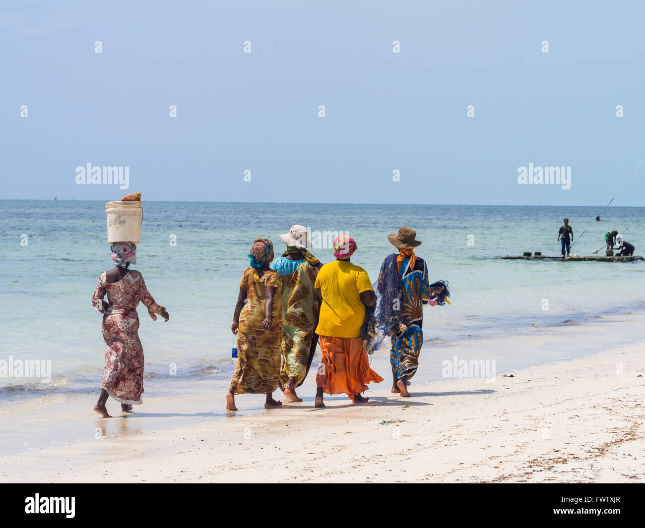 Donne locali andare a pesca su una spiaggia a Zanzibar, Tanzania. Foto Stock