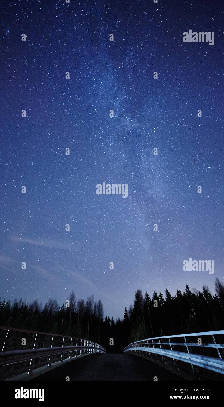 Un cielo notturno pieno di stelle e visibile la Via Lattea con un ponte sul primo piano. Simbolo di avvio di un infinito viaggio a stella. Foto Stock