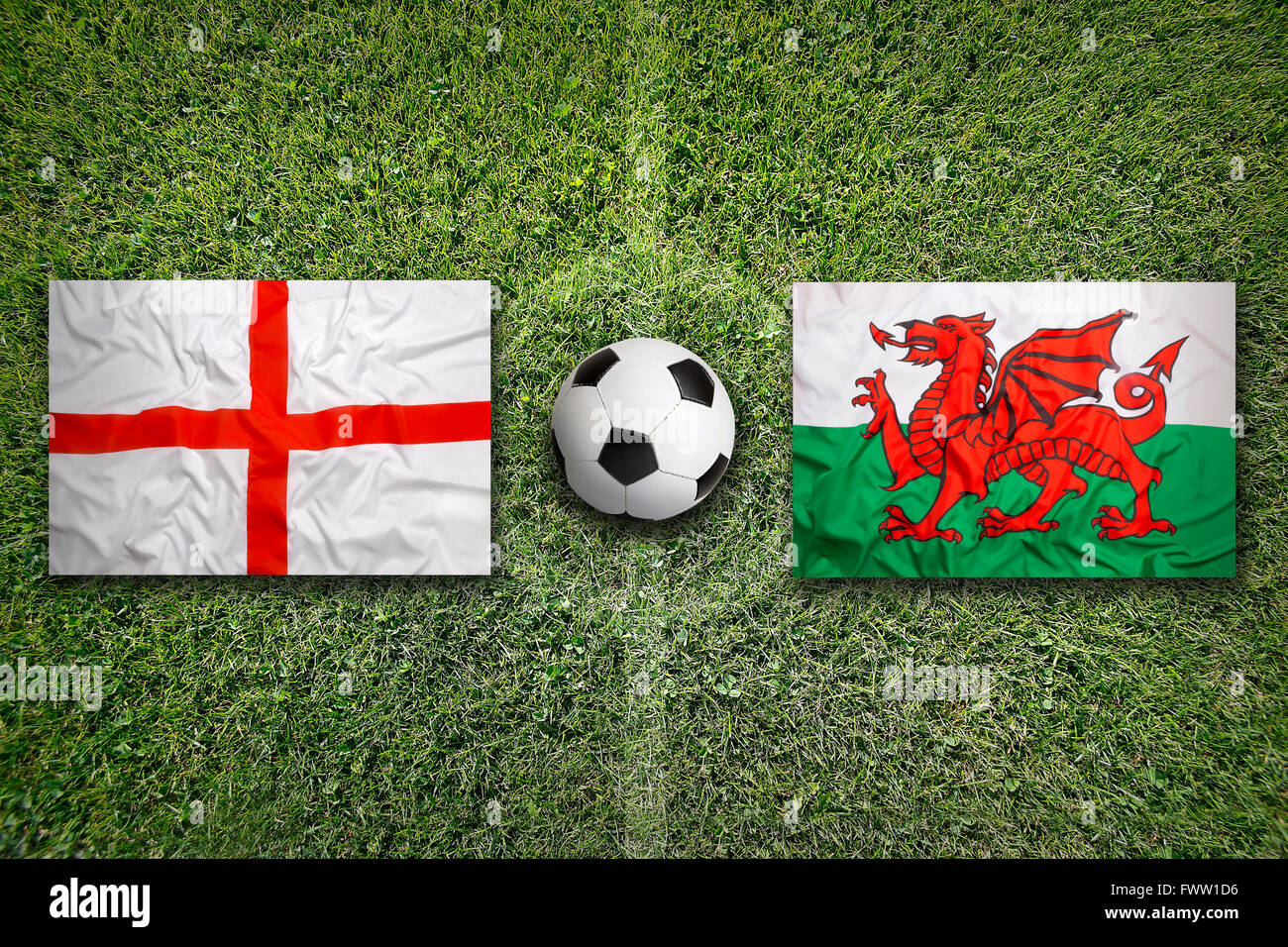 Inghilterra contro il Galles bandiere sul verde del campo di calcio Foto Stock