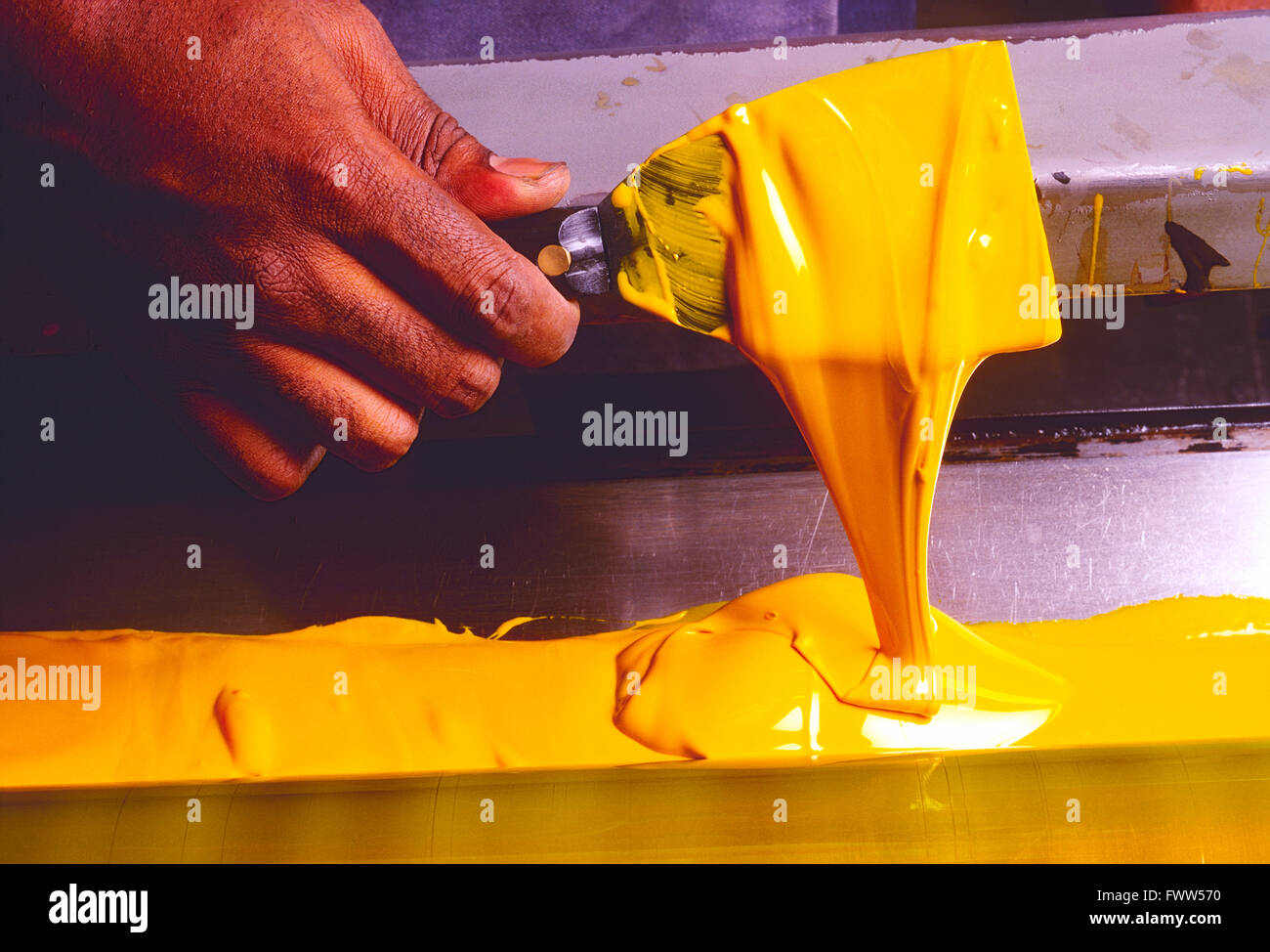 Close-up di African American printer la mano diffusione di inchiostro di stampa con una lama lo strumento Mano Foto Stock