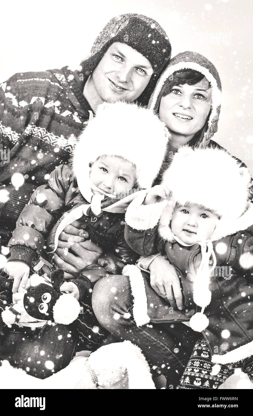 Famiglia con due piccole figlie in posa nella neve Foto Stock