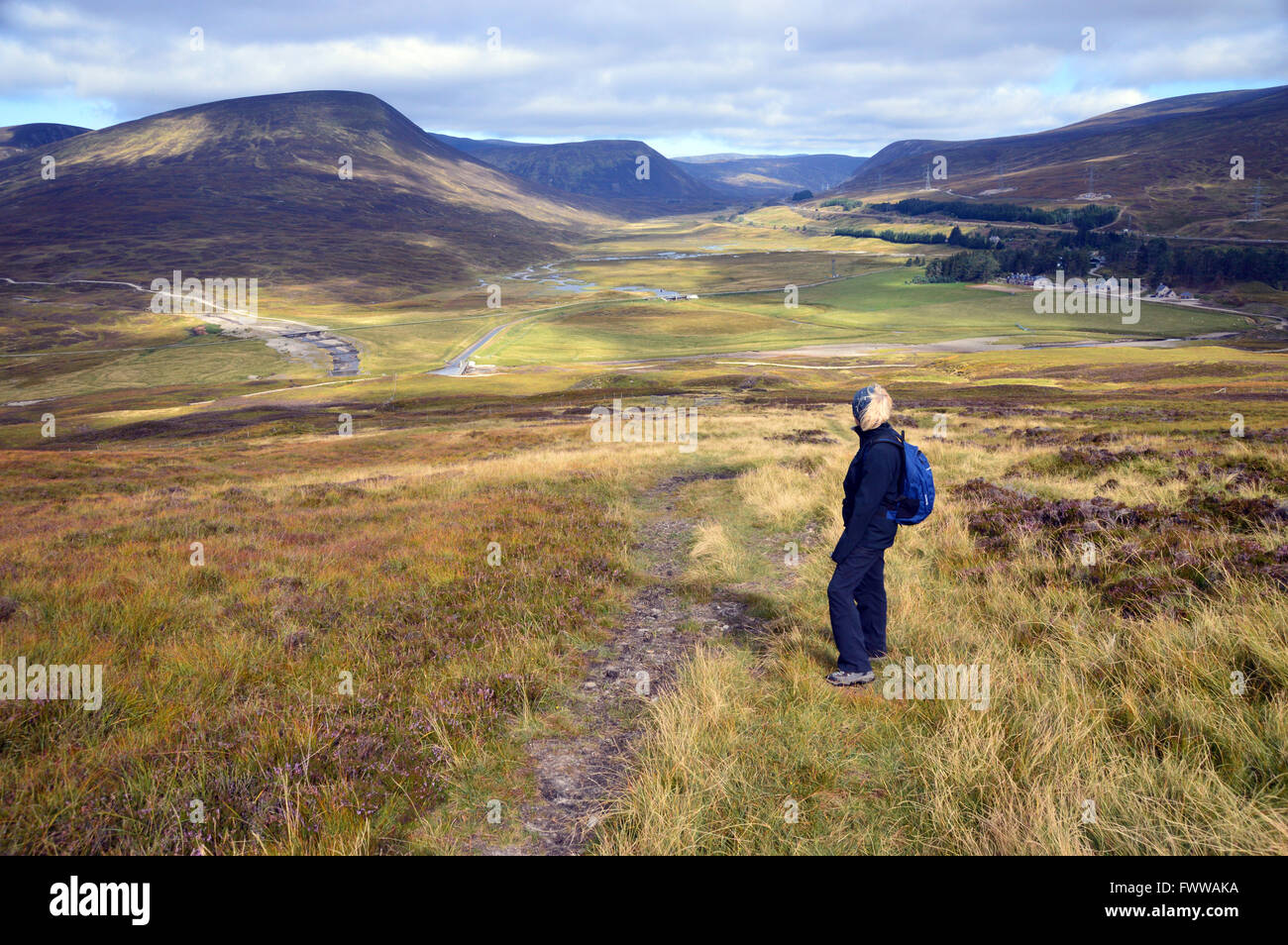 Lone Donna che guarda verso il basso per Dalnaspidal Lodge nel Drumochter passano dal Corbett Meall na Leitreach, Highlands Scozzesi. Foto Stock