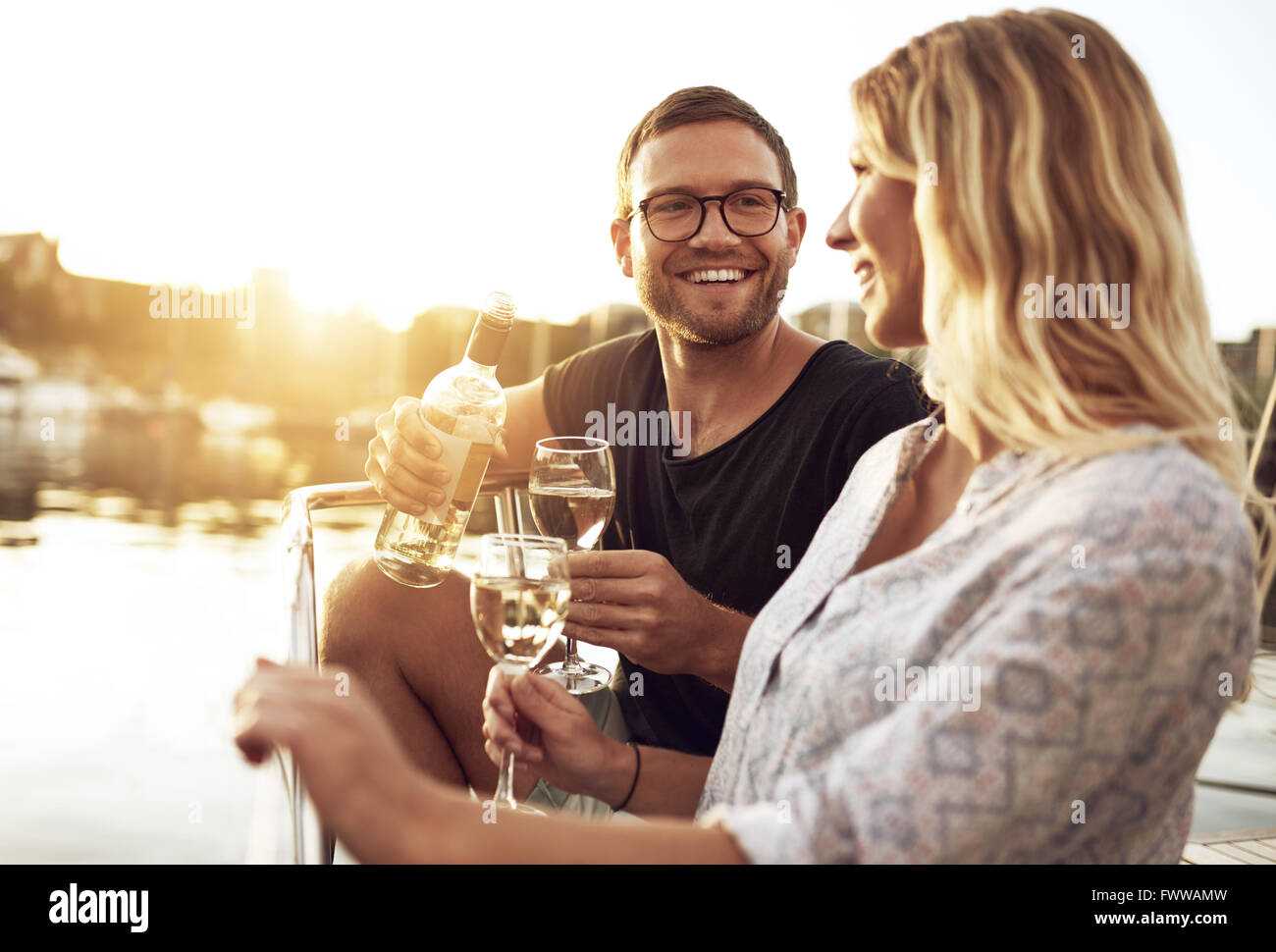 L uomo e la donna si beve vino al di fuori di un giorno di estate Foto Stock
