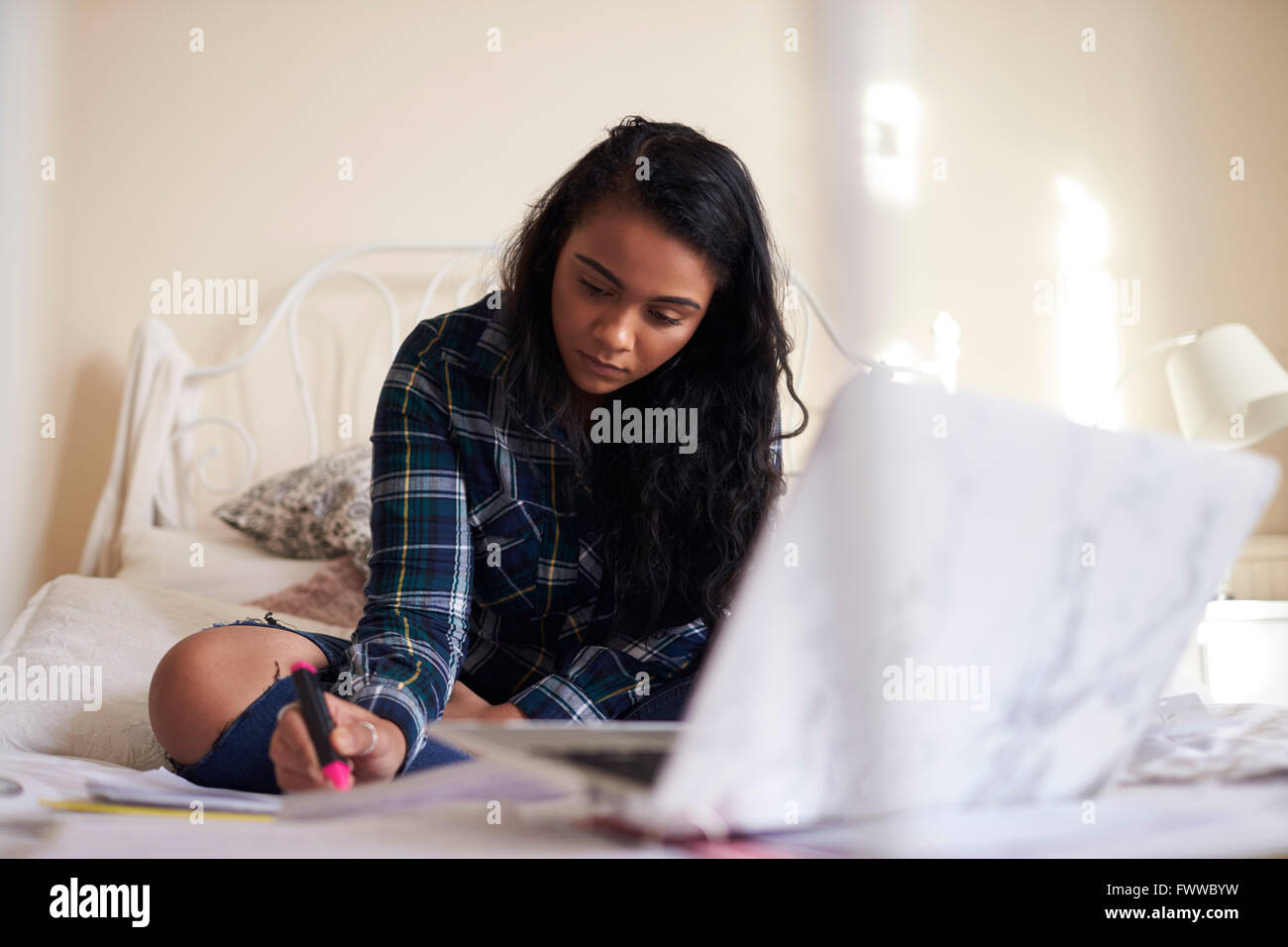 Studentessa con Laptop lavorando su studi in camera da letto Foto Stock