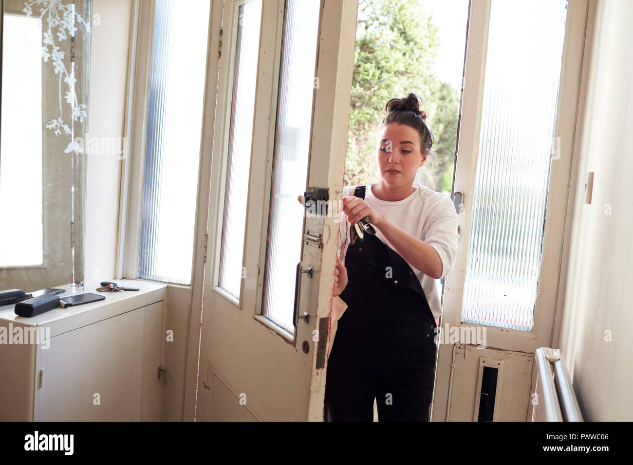 Studentessa apertura porta anteriore di alloggio condiviso Foto Stock