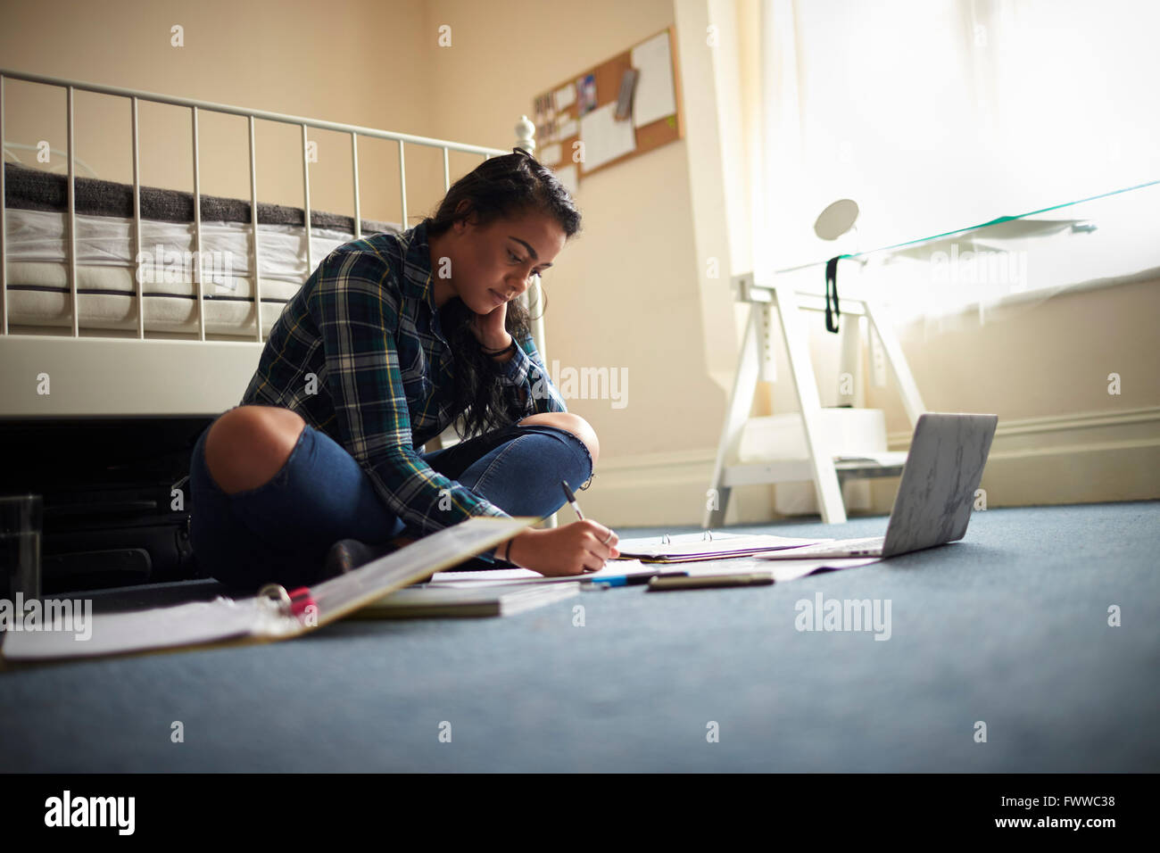 Studentessa con Laptop lavorando su studi in camera da letto Foto Stock