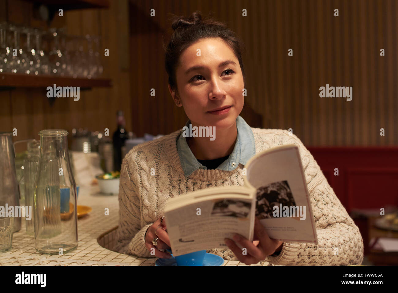 Giovane donna libro lettura In Coffee Shop Foto Stock