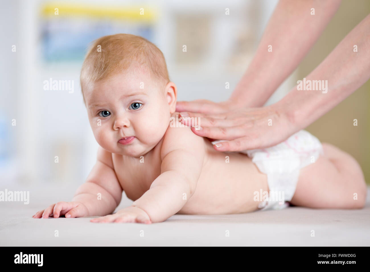 La madre o il terapista di massaggio rende al suo bambino a casa. La cura della salute e la medicina del concetto. Foto Stock