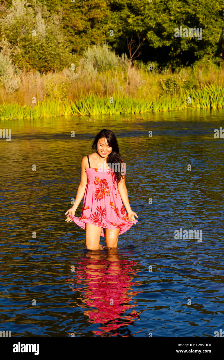 Bella asiatica American Woman Standing in fiume Foto Stock