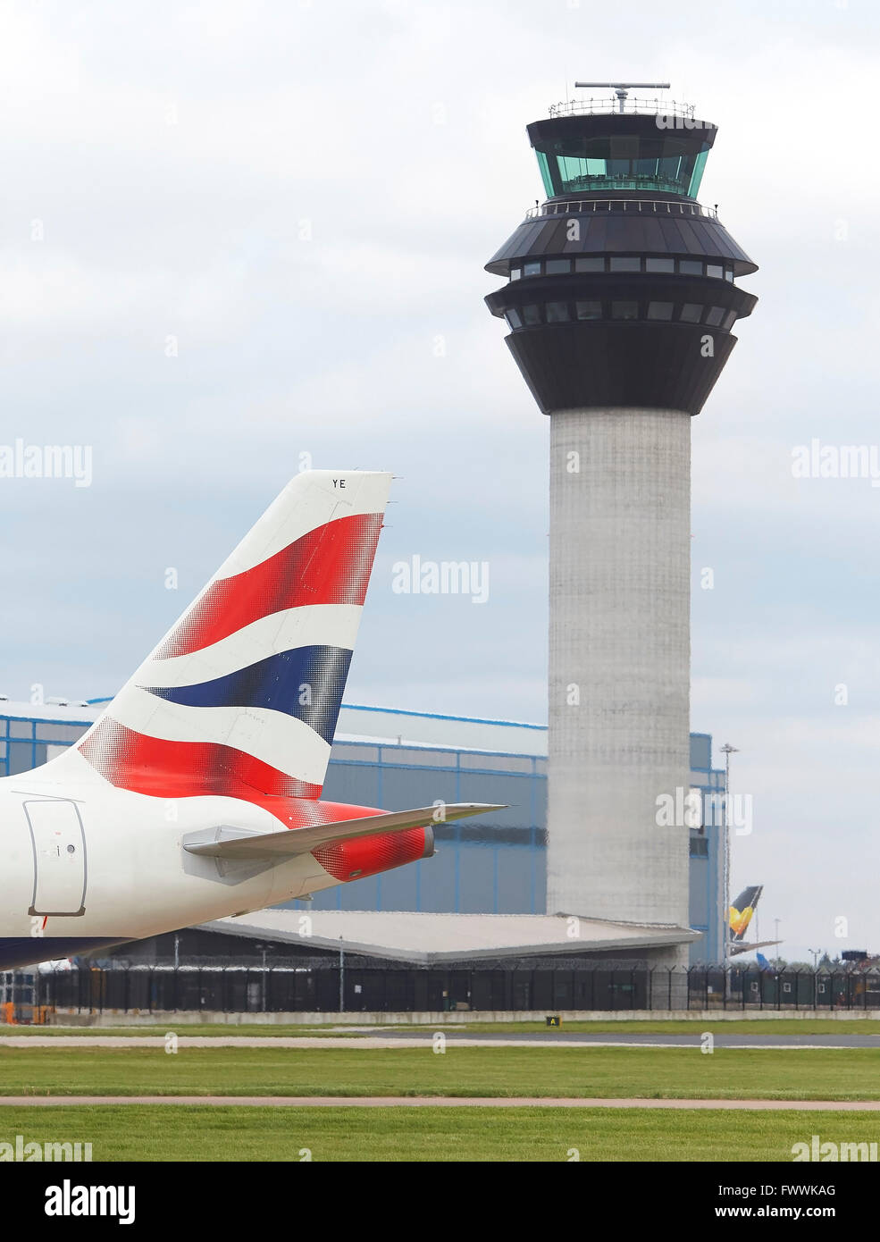 La giustapposizione di pinna di coda e la torre di controllo. Aeroporto di Manchester, Manchester, Regno Unito. Architetto: n/a, 2015. Foto Stock
