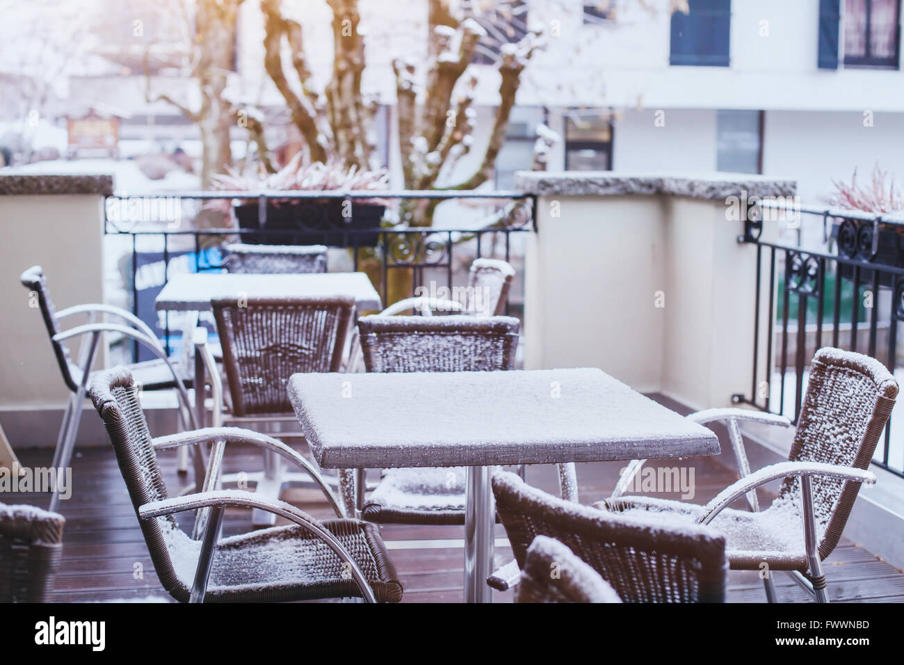 Terrazza del caffè strada in inverno, tavoli e sedie coperte da neve Foto Stock