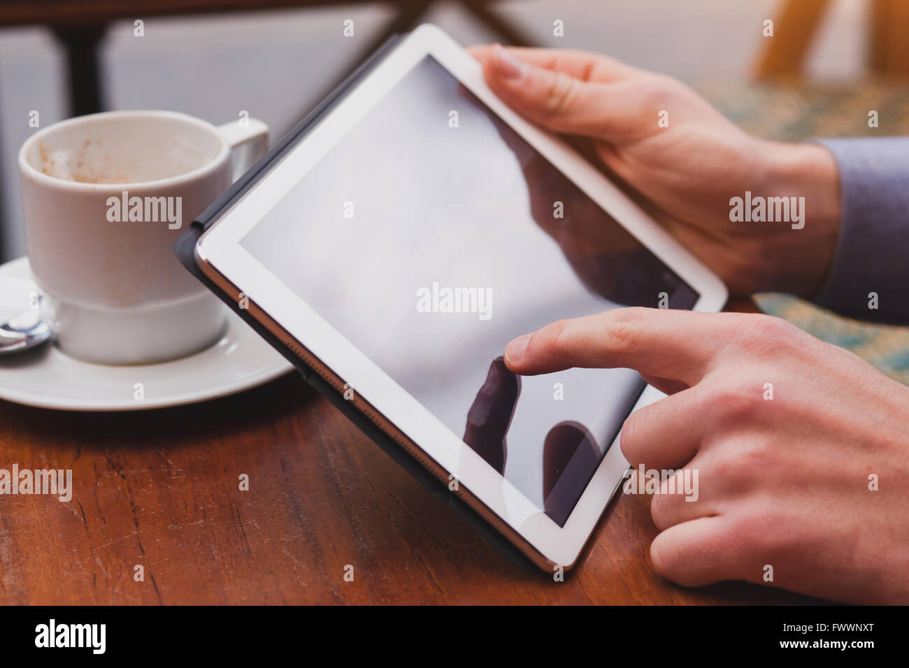 Utilizzo di internet su tablet in cafe, il controllo della posta elettronica e le reti sociali sul touchpad, primo piano del dito Foto Stock
