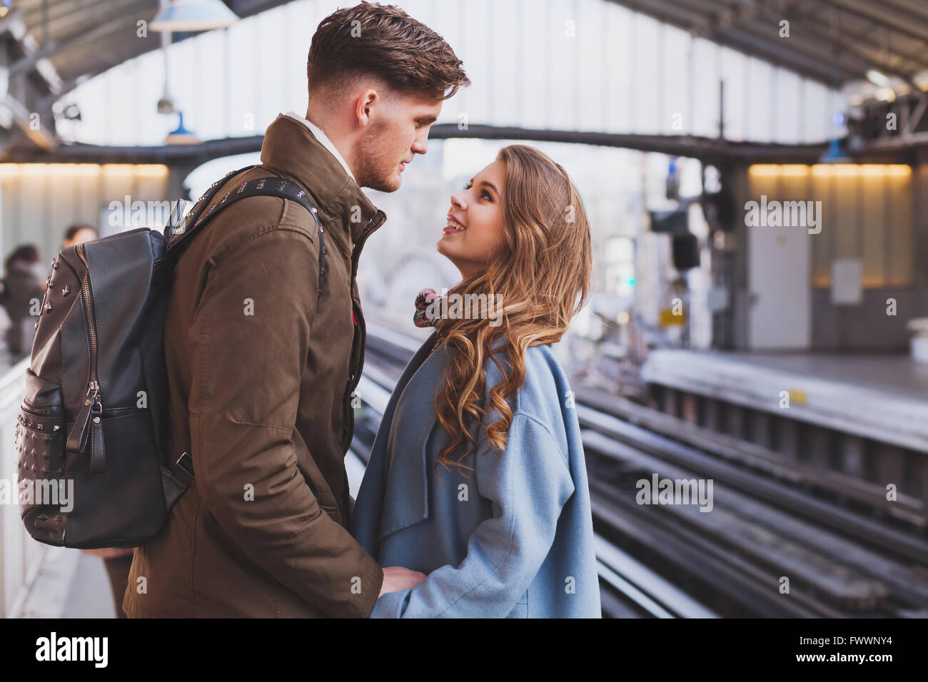 Distanza lunga relazione, giovane sul binario presso la stazione dei treni, un incontro o un concetto di separazione Foto Stock