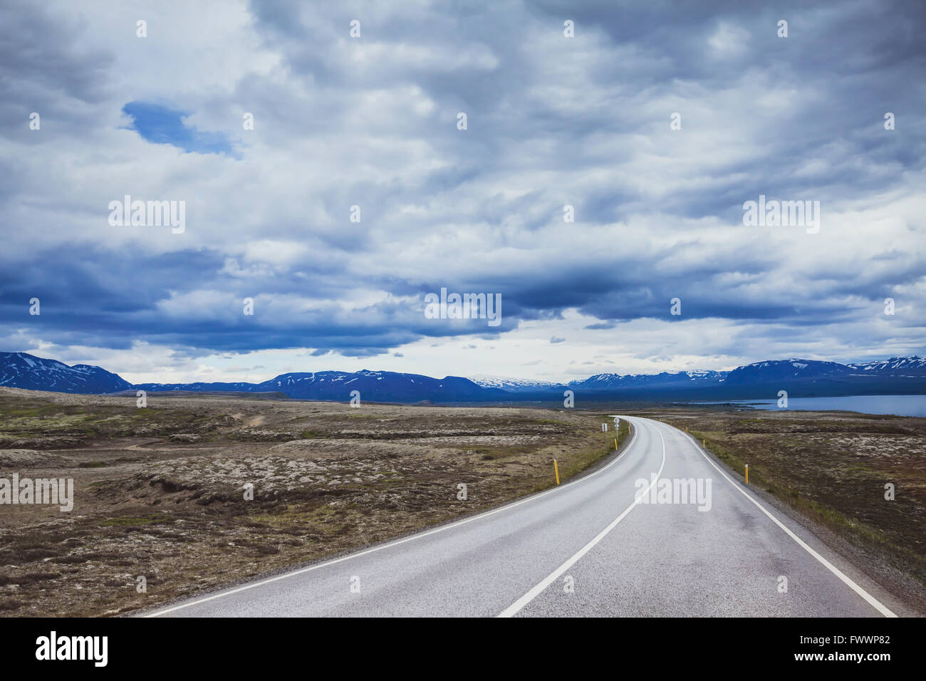 Sfondo di viaggio, bella strada asfaltata nel drammatico paesaggio di Islanda Foto Stock