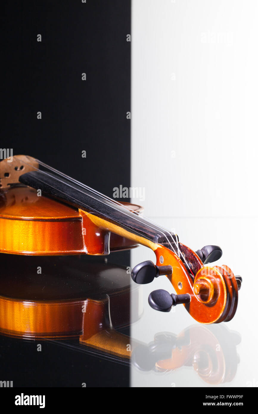 Vecchio violino isolato in bianco e nero e sfondo scrivania in vetro Foto Stock