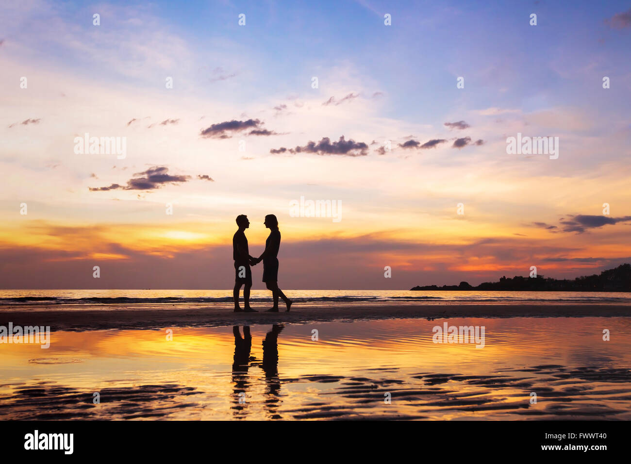 Silhouette di affettuosa giovane sulla spiaggia al tramonto, amore concetto, uomo e donna, bello sfondo Foto Stock