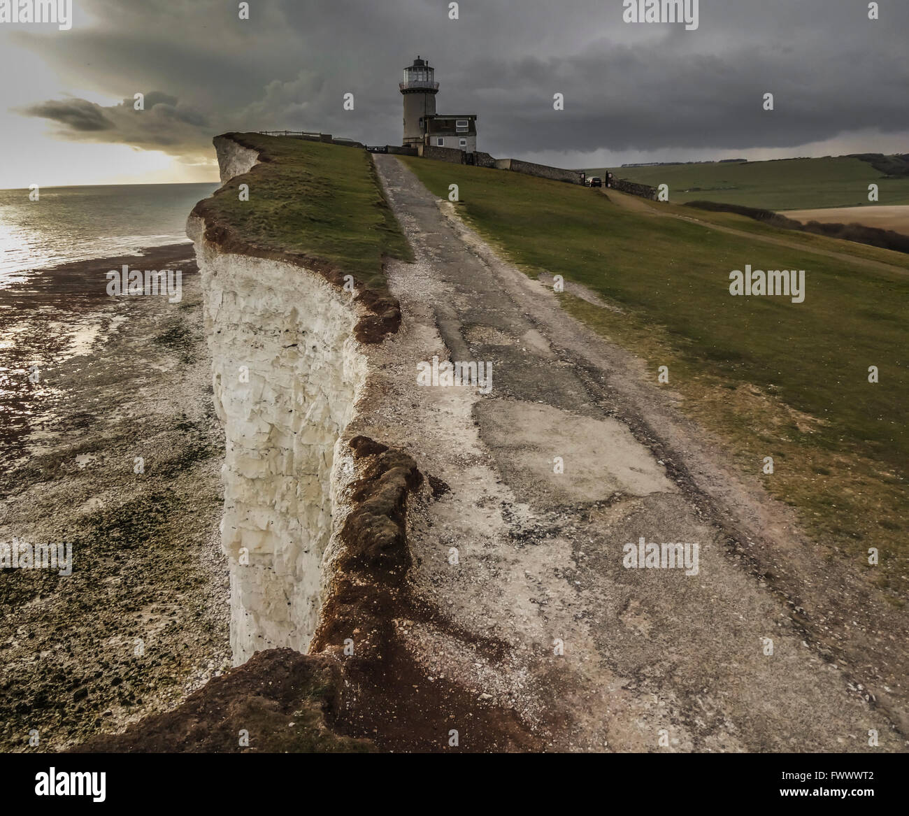 Eastbourne, East Sussex, UK..7 aprile 2016..Storm nuvole in avvicinamento Belle Tout Faro arroccato sulla cima delle scogliere di gesso... Foto Stock