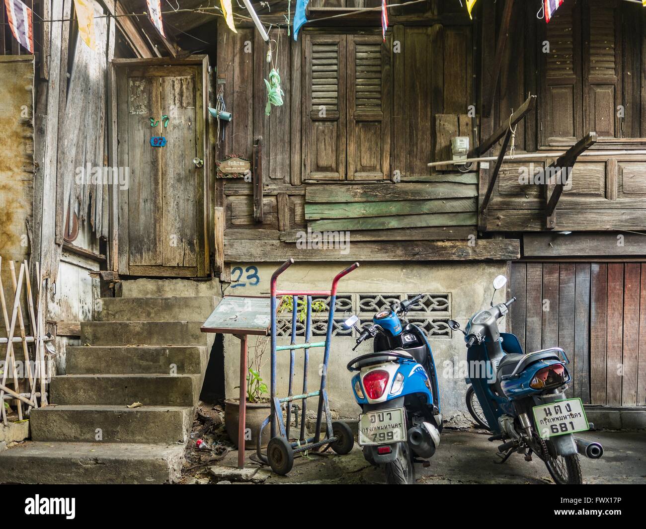 Bangkok, Tailandia. 7 apr, 2016. Due ciclomotori al di fuori di una antica di 200 anni in casa Mahakan Fort, uno degli originali case squatter" comunità, costruito senza chiodi utilizzando una tecnica di incuneamento.Il basamento in cemento è stato aggiunto un paio di anni fa. Un avviso finale è stato dato e residenti e deve abbandonare prima di aprile 30th. Dopo che le loro case, alcune delle quali sono quasi duecento anni, saranno distrutti. © Jack Kurtz/ZUMA filo/Alamy Live News Foto Stock