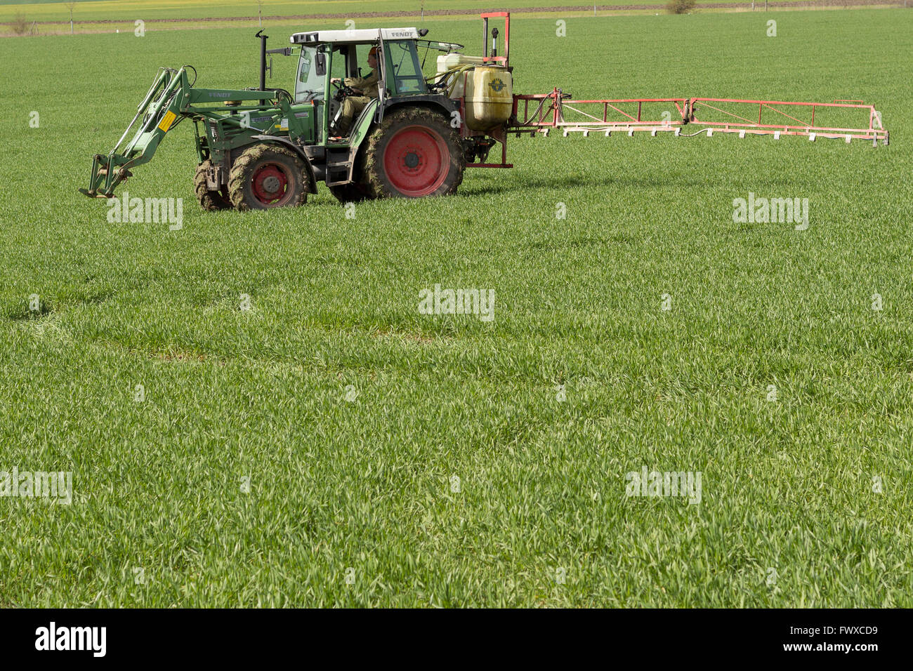 Il trattore di spruzzatura campo verde - agricoltura sfondo Foto Stock