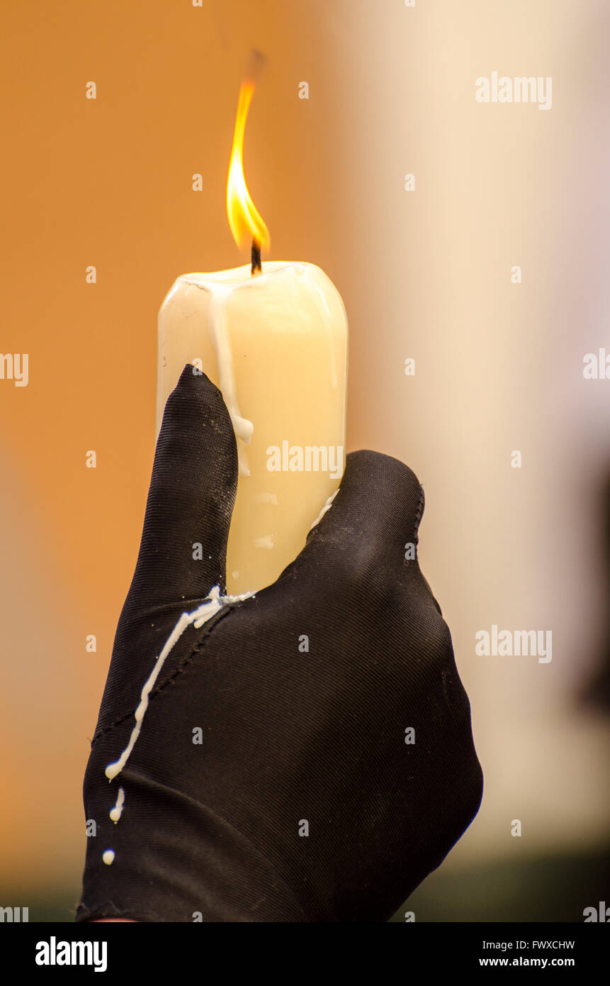 Penitente tenendo una candela di cera di gocciolamento durante la Semana Santa processioni della città di Cadiz Spagna 2016 Foto Stock