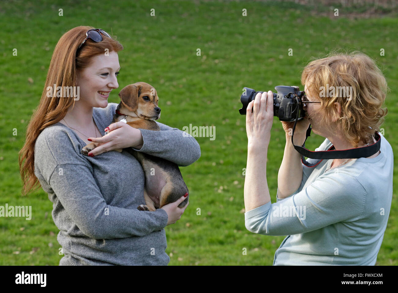 Madre di scattare le foto della figlia con il suo cane di piccola taglia Foto Stock