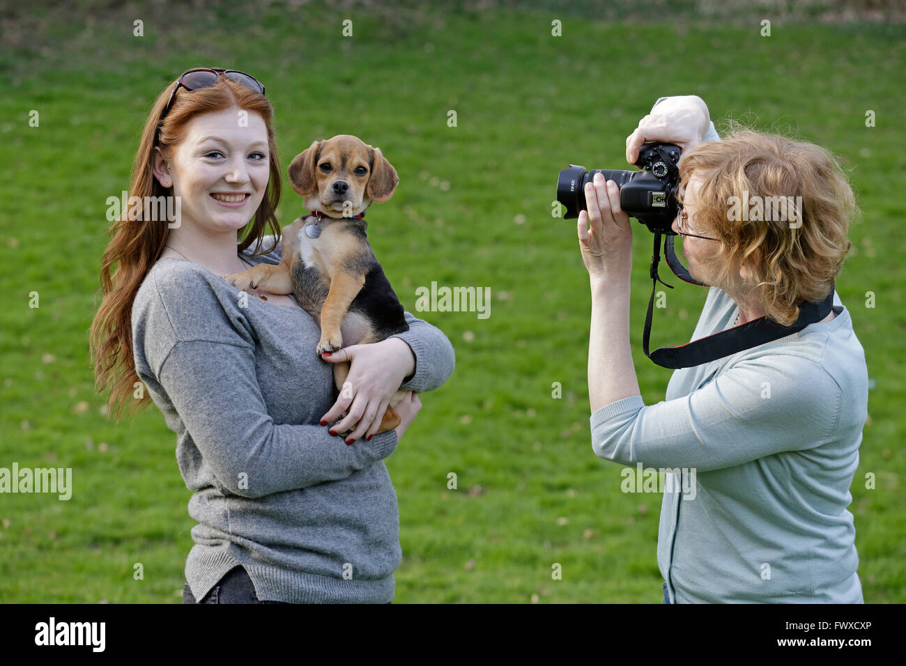 Madre di scattare le foto della figlia con il suo cane di piccola taglia Foto Stock
