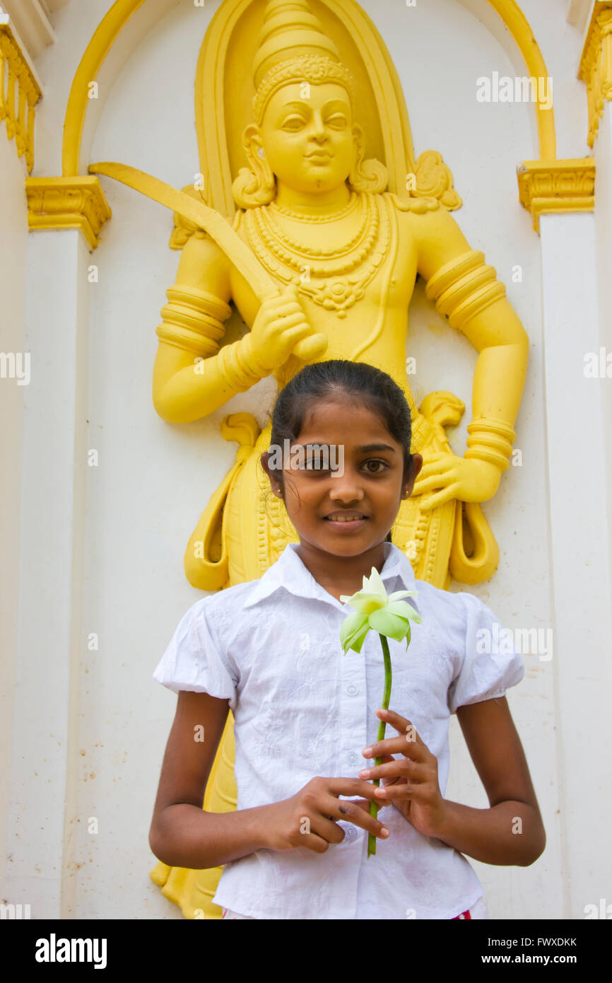 Bambina tenendo un fiore di loto a Ruwanwelisaya Dagoba, Anuradhapura (Patrimonio Mondiale dell'UNESCO), Sri Lanka Foto Stock
