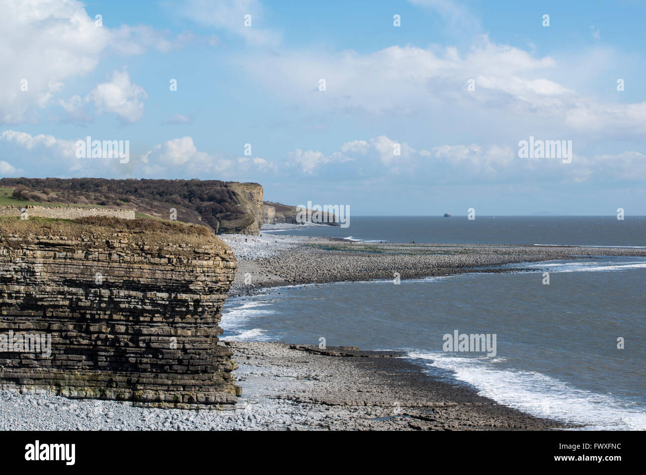 Un dito di ciottoli si estende nel mare st col-huw punto. Foto Stock