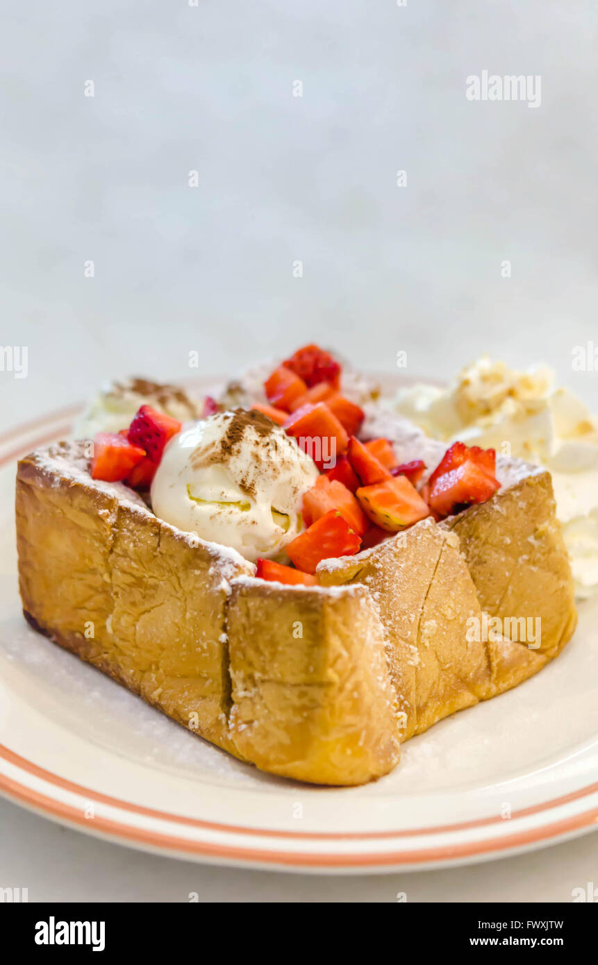 Fragola miele toast con gelato e panna montata Foto Stock