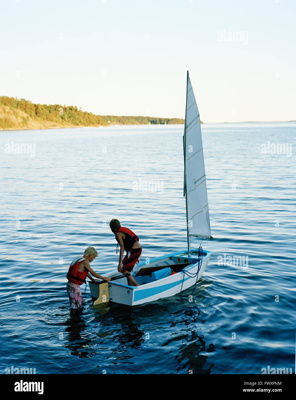 La Svezia, Stoccolma, due ragazzi (8-9, 16-17) sulla barca a vela sul lago Foto Stock