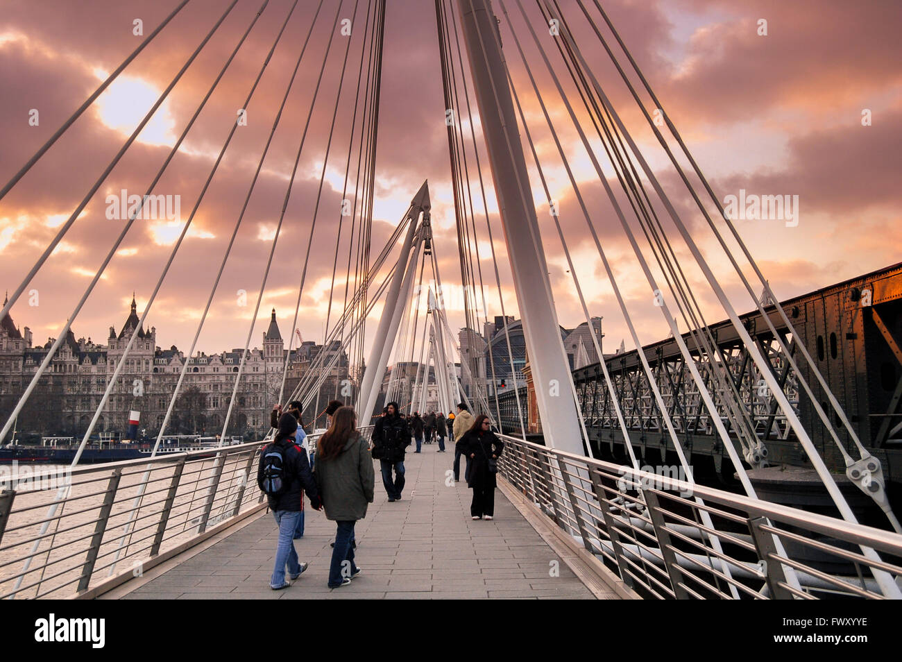 Camminando lungo il Golden Jubilee Bridge di Londra al tramonto. Foto Stock